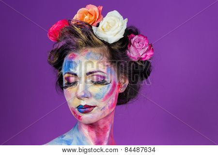 Beautiful cute girl decorated with colorful paints, hair roses.