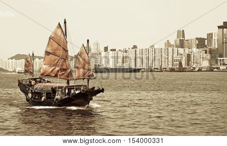 Junk boat with tourists in Hong Kong Victoria Harbour