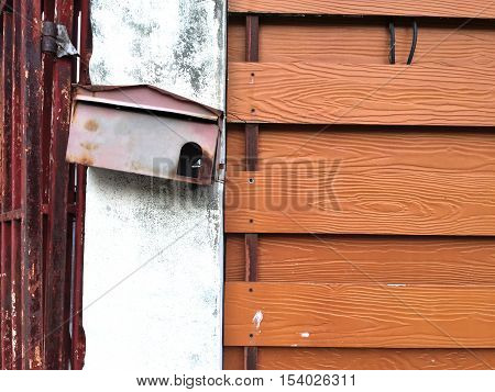 Old red mailbox on concrete pole. Vintage wall