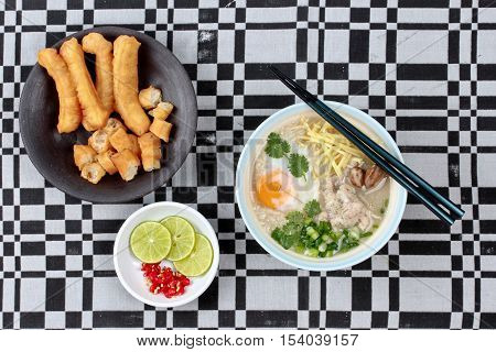 Rice porridge with mined pork and chicken lever served with side dish as Patongko (deep-fried dough stick) and spicy sour filling.