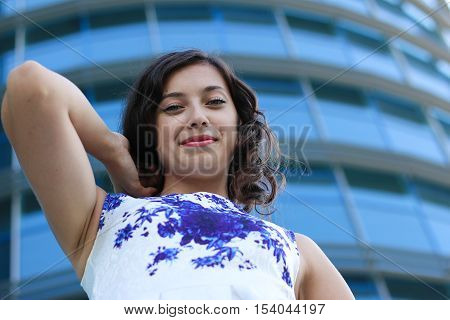 Beautiful smiling brunnete lady in white-blue dress outdoors