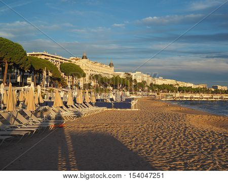 CANNES-SEPT. 13: The beach at dusk is seen in Cannes France with Carlton and Martinez hotel and cafes on famous Promenade de la Croisette on September 13 2015.