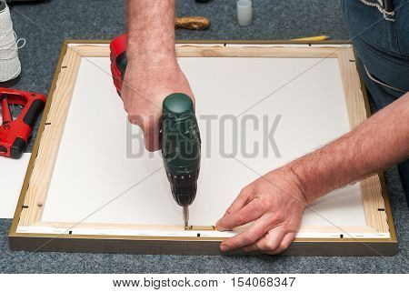 Craftsman working on frame in frame shop. Professional framer hand holding frame angle. Top view. Copy space.