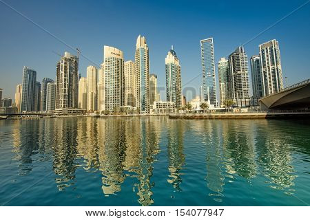 DUBAI, UAE - OCTOBER 09, 2016: Dubai Marina is a man made marina stretching over 3km of land. Surrounded by tall unique skyscrapers with apartments and restaurants, the marina is open to The Gulf.