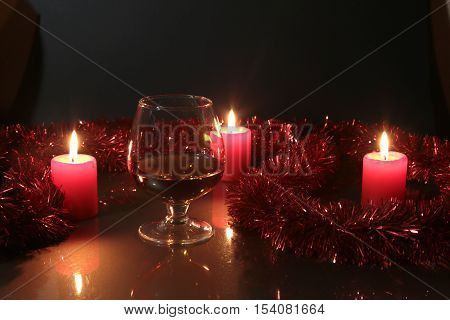 Christmas Photo Cognac Glass And Candle On Black Background