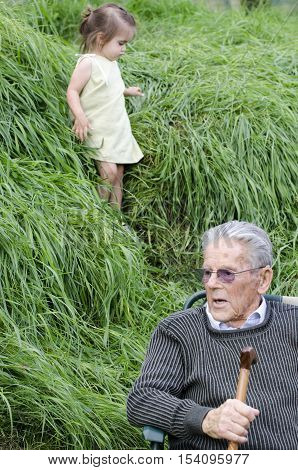Great Grandfather and his little great grandchild plays. Difference of young and old concept
