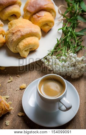 Breakfast with espresso and a croissant on old wooden table