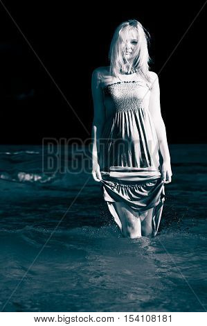 Leisure spare time activities. Young woman chilling out on the beach. Lady spending free moments outside. Attractive girl has white dress.