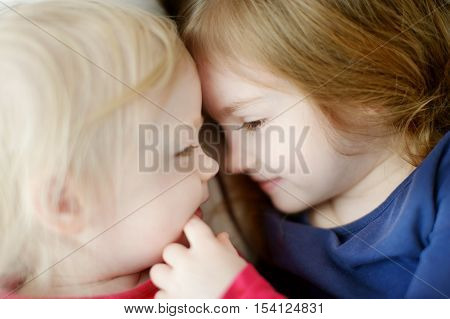 Sister love: two little girls hugging at home