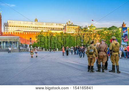 MOSCOW RUSSIA - MAY 10 2015: The people in Second World War Soviet soldiers uniform at the Kremlin Wall during Victory Day celebration on May 10 in Moscow.