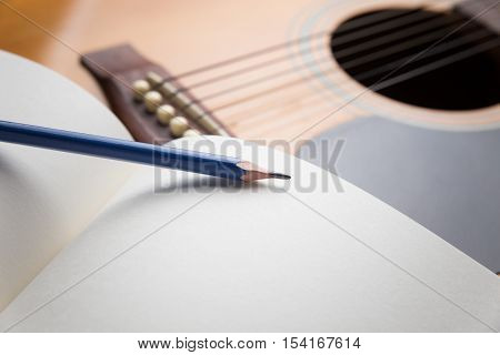 Pencil, Notebook and pencil on guitarWriting music