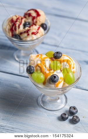 Bowl of ice cream with fruits on old wooden table