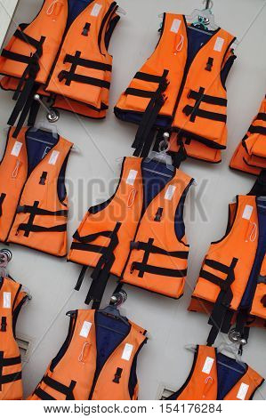 Rows of orange life jackets on the wall, ready for immediate use.
