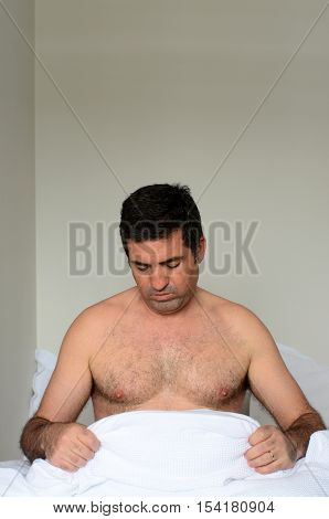 Upset Man In His Forties (40S) In Bed Looking Down At His Penis