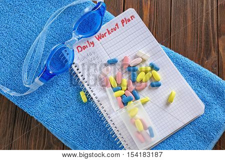 Notebook and drugs on wooden background