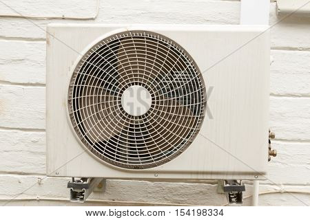 Weathered White Airconditioning Unit Mounted On Exterior Home Wall