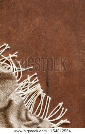 warm wool throw plaid on wooden background