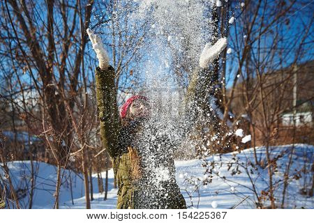 Girl playing with snow in winter park