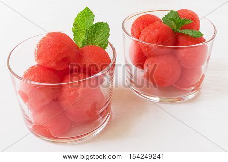 Healthy summer dessert. Watermelon balls with mint on white wooden table selective focus vertical