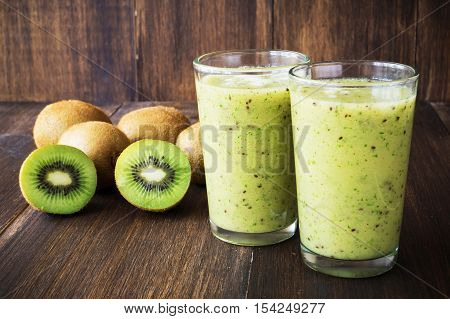 Kiwi green smoothie in glass on wooden background selective focus toned horizontal