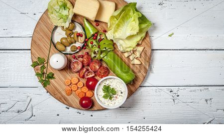Fresh vegetables and cheese on white retro wooden table