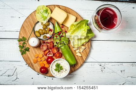 Fresh vegetables and cheese on white retro wooden table
