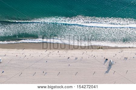 Aerial view of Santa monica beach from elicopter. Bathers and people standing and walking on the sand