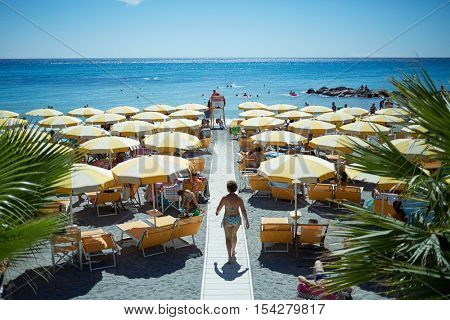 LIGURIA, ITALY - AUG 06, 2016: People on coastline beach. Ligurian coast is the national pride of the Italians.