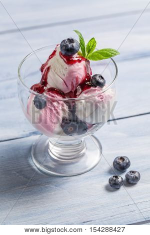 Bowl with fresh blueberry ice cream on wooden table