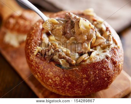 eating philly cheese steak sourdough breadbowl