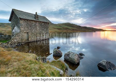 An old stone boat house on the shores of Devoke Water at the foot of Birker Fell in the Lake District in Cumbria