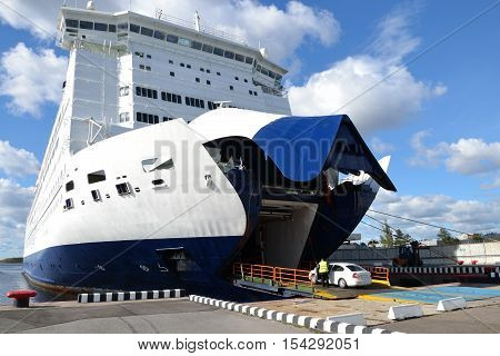 White car entering the deck of a large ferry boat