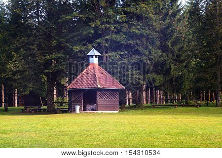 View of barbeque house on grass in front the trees