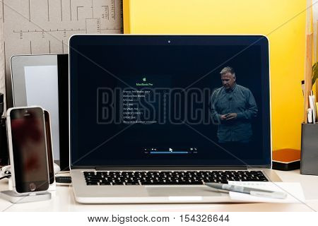 PARIS FRANCE - OCT 28 2016: Apple Computers website on new MacBook Pro Retina with OLED Touch bar in geek creative room showcasing Apple Keynote presentation of Ecologial impact of new MacBook Pro