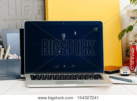 PARIS FRANCE - OCT 28 2016: Apple Computers website on new MacBook Pro Retina with OLED Touch bar in geek creative room showcasing Apple Keynote presentation of Tim Cook saluting audience