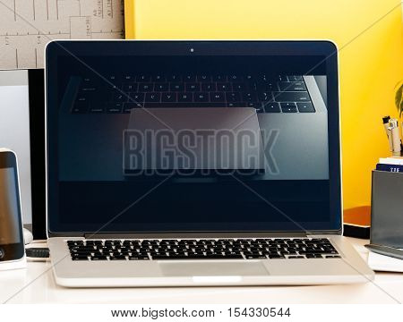 PARIS FRANCE - OCT 28 2016: Apple Computers website on new MacBook Pro Retina with OLED Touch bar in geek creative room showcasing Apple Keynote presentation of Jhony Ive presenting the new laptop film with trackpad specks
