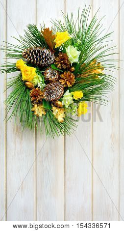 Christmas wreath with yellow fabric roses and golden pinecones. Christmas party decoration. Christmas greeting background. Copy space.