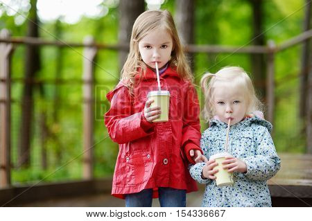 Two Little Sisters Drinking Hot Cholocate