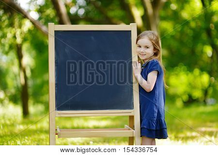 Very Excited Little Schoolgirl By A Chalkboard