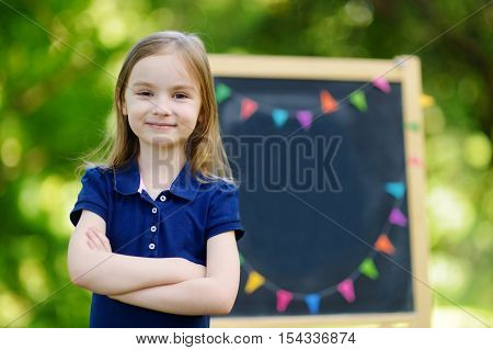 Very Excited Little Schoolgirl By A Chalkboard