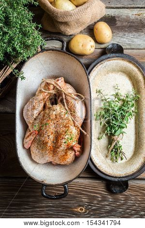 Preparing chicken with spices on wooden table