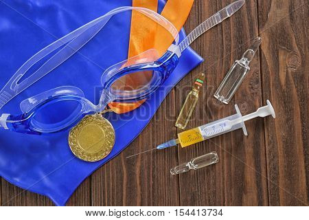 Sports equipment and syringe on wooden background