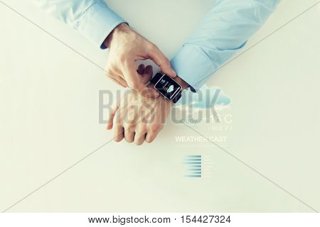 business, technology, weather forecast, application and people concept - close up of male hands setting smart watch with meteo cast on screen