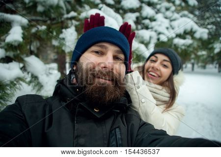 Happy couple making selfie photo outdoors. closeup of a caucasian and loving couple is doing selfie on smartphone. lifestyle people and outdoor concept and idea
