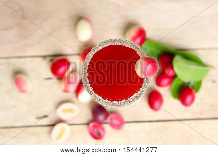 Carandas-plum  juice  in a glass on wooden background