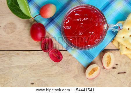Carandas-plum  juice  in a glass on wooden background