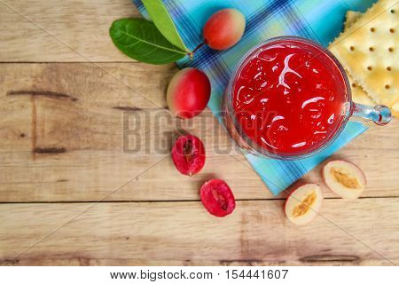 Carandas-plum  juice  in a glass on wooden background