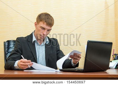 A man looks through documents at office