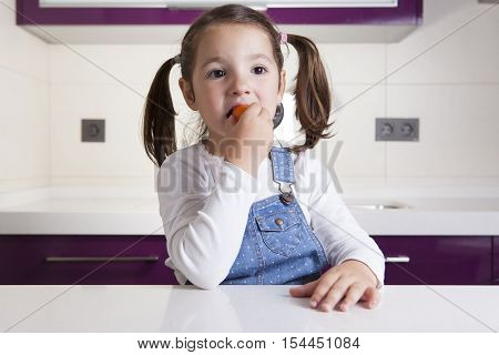 Little girl tasting a raw colorful cherry tomatoe