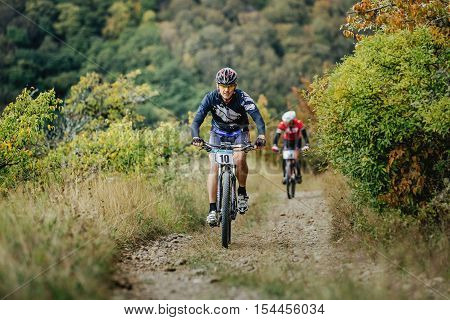 Privetnoye Russia - September 22 2016: middle-aged man racer cyclist riding uphill during Crimean race mountainbike